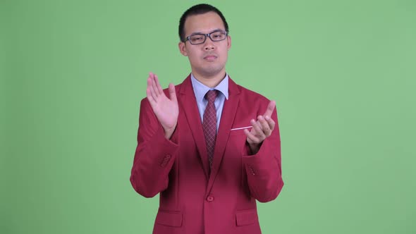 Asian Businessman with Eyeglasses Clapping Hands
