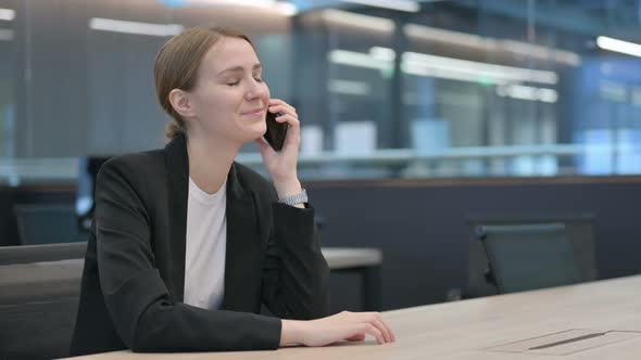 Businesswoman Talking on Smartphone at Work