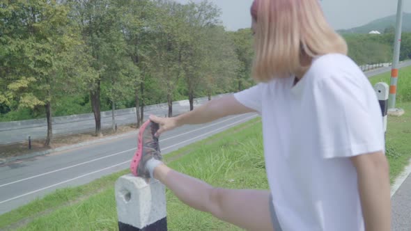 Woman legs warming and stretching her arms to ready for running on street.