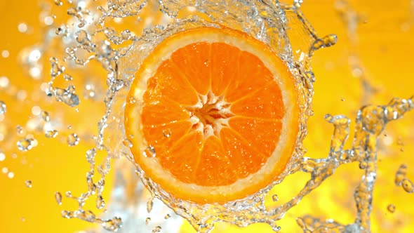 Super Slow Motion Shot of Rotating Fresh Orange Slice and Splashing Water at 1000Fps alt