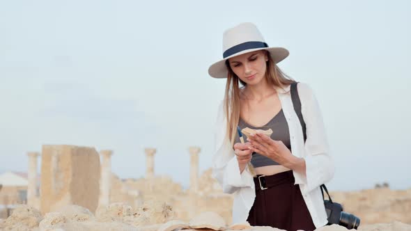 Woman Examining Ancient Ruined Temple