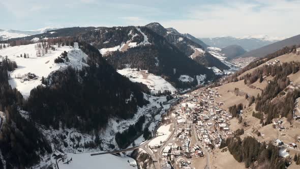 Dolly forward drone shot over st cristina mountain village towards Ortisei Dolomites