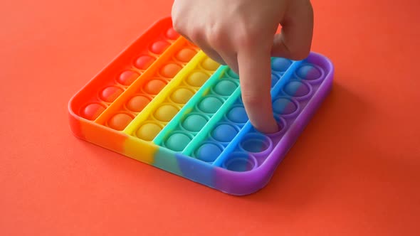 Close-up of a child's hands pushing and popping a game Pop it.