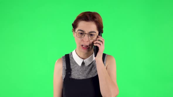 Portrait of Funny Girl in Round Glasses Is Angrily Talking for Mobile Phone, Proving Something