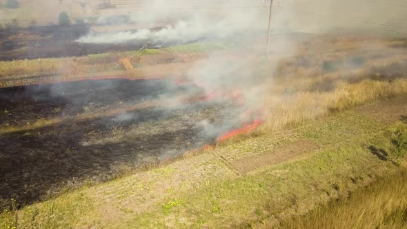 Aerial view of burning grass in field.