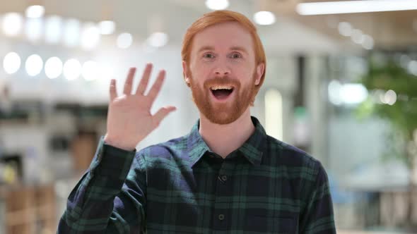 Portrait of Welcoming Beard Redhead Man Waving at the Camera