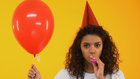 Sad Teenage Girl Blowing Party Horn, Bored on Birthday Celebration, Loneliness