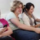 Teenage girl texting on smartphone, friends playing video game - VideoHive Item for Sale