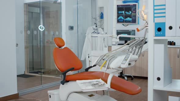 Revealing Shot of Orthodontic Chair with Nobody in Teeth x Ray Images on Modern Display