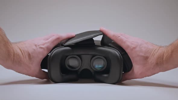 Man's Hands Take Vr Glasses and Wear Them at White Background