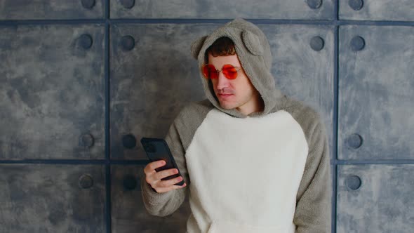 Man in Kigurumi and Sunglasses Using Smartphone