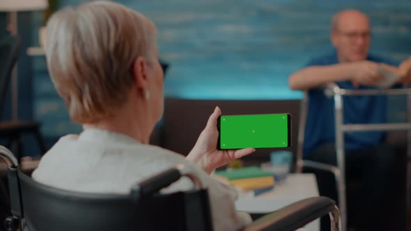 Retiree with Disability Using Horizontal Green Screen on Mobile Phone