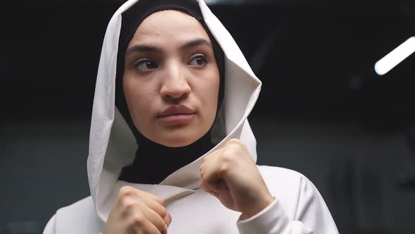 Arab Athlete a Muslim Standing in the Pose of a Fighter Boxing in a Fitness Center Wearing a White