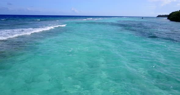 Beautiful birds eye tourism shot of a white sandy paradise beach and blue ocean background