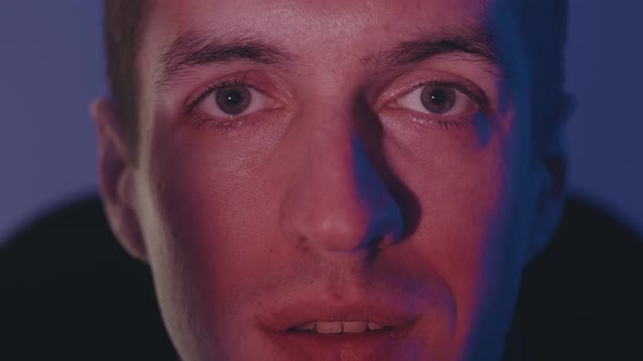 Close Up Face of Young Man with Reflection of Video While Watching Movie Film on TV or a Computer