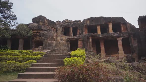 Slowly walking up stone steps approaching an ancient hand carved stone temple