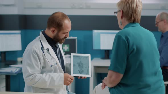 Male Doctor Showing Human Skeleton Illustration on Digital Tablet
