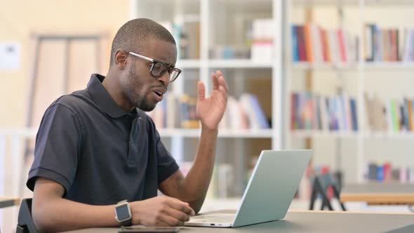 Shocked Young African Man Reacting To Failure in Library