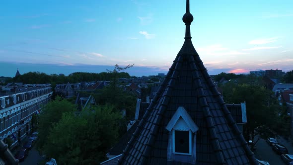 Cinematic shot floating over a city balcony revealing a small town skyline during sunset.