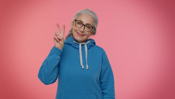 Mature Grandmother Showing Victory Sign Hoping for Success and Win Doing Peace Gesture Smiling