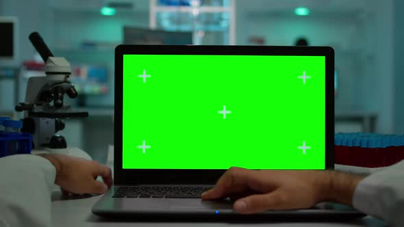 Pov Shot of Scientist Working on Laptop with Mockup Green Screen