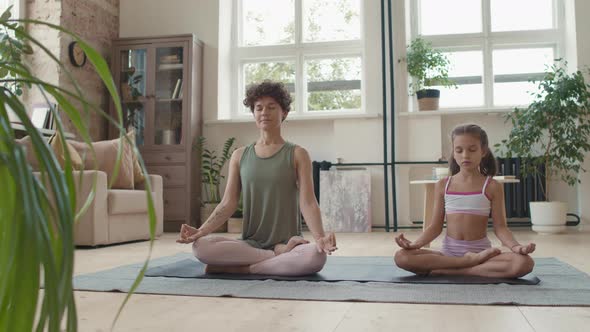 Mother and Daughter Meditating at Home