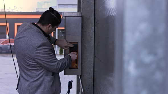 Man on Selfservice Carwash Inserts Cash for a Using on a Bill Acceptor