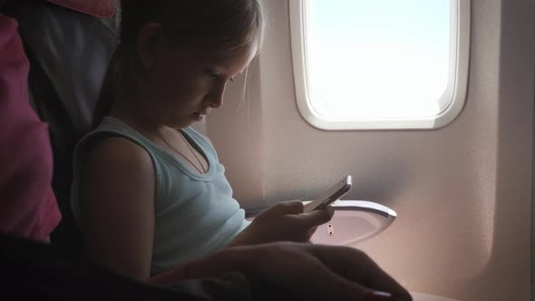 Adorable Girl Traveling By an Airplane and Using a Digital Tablet During the Flight. Concept