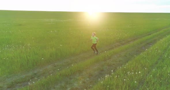 Sporty Child Runs Through a Green Wheat Field