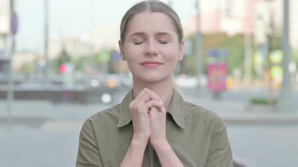 Woman Praying with Folded Hands while Standing Outdoor