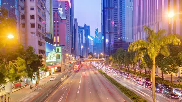 Hong Kong Street with Busy Traffic and Skyscraper Office at Dusk Day to Night Timelapse
