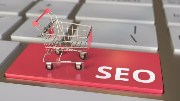 SEO Text on Computer Keyboard and Boxes in Small Shopping Cart