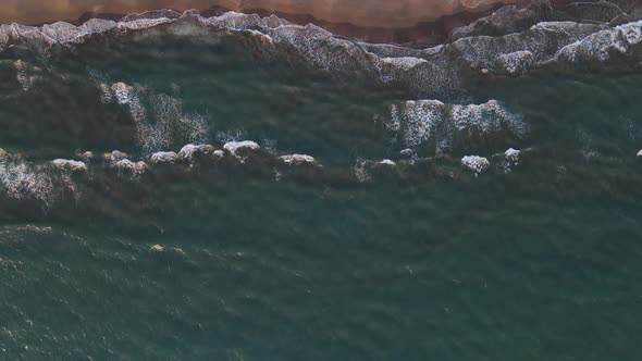 Foamy Waves Crash on the Wide Beach