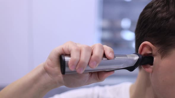 Close Up Man Using Special Trimmer to Automatic Cut Hair in the Ears