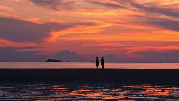 People Walking By the Beach at Sunset