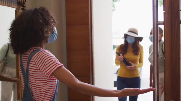 Diverse group of happy female friends wearing mask greeting with elbow bump