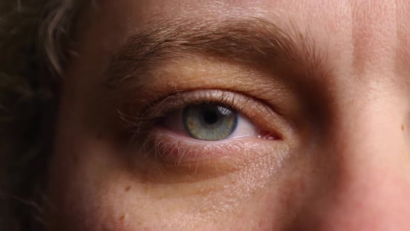 Close-up of a woman's blue eye. Human pupil. The eyelid blinks several times