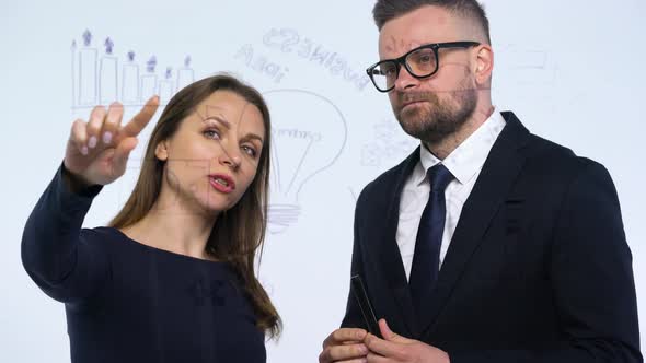 Man and Woman Discuss the Business Strategy for Success in a Modern Glass Office