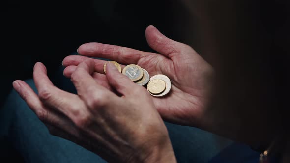 Wrinkled Hands of Elderly Woman Counting Coins