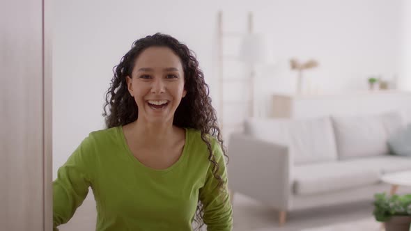 Woman Opening Door And Gesturing Inviting To Come In Indoor