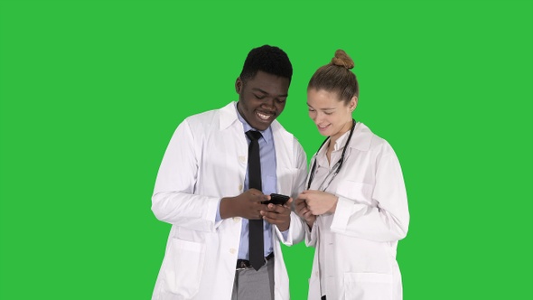 Medical team looking at phone together on a Green Screen