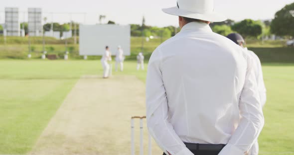 Rear view of cricket payer throwing a ball