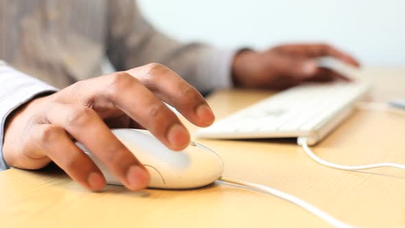 Male working on computer, keyboard and mouse on desk in office