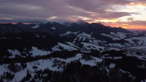 Aerial View Sunset Over Winter Mountain Trees Landscape Colored Clouds at Dusk