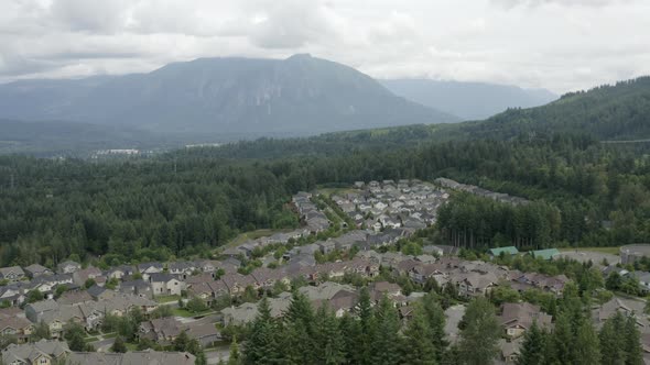 Flying Away From Snoqualmie Ridge With View Of Mount Si - Forested Suburban Housing Development