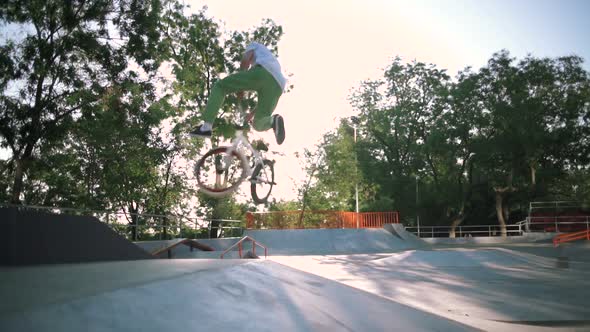 BMX Riders Doing Tricks in Extreme Park During Sunset Slow Motion