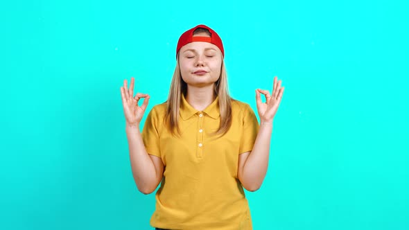 The Young Woman Keeps Her Fingers in the Shape of a Yoga, Tries To Relax, Calm Down