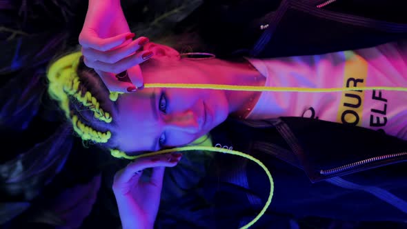 Millennial Young Woman with Yellow Hair in Trendy Neon Pink and Blue Lights