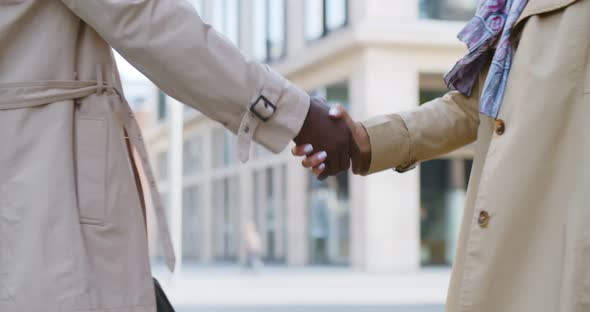 Close Up of Afro Businesspeople Shaking Hands Outdoors