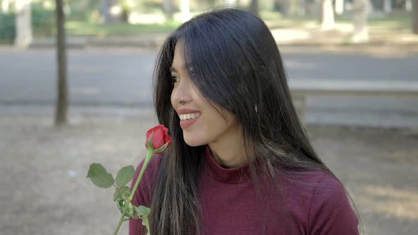 beautiful AsianAsian woman smelling a rose at the park.love, romance-slow motion